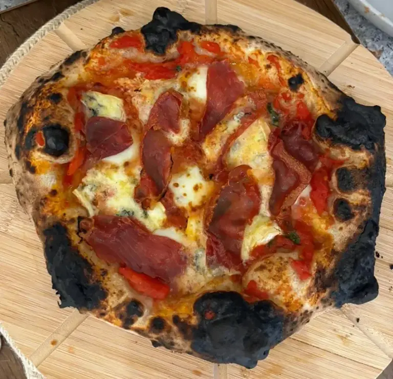 A Neapolitan pizza baked unevenly in a wood-fired oven