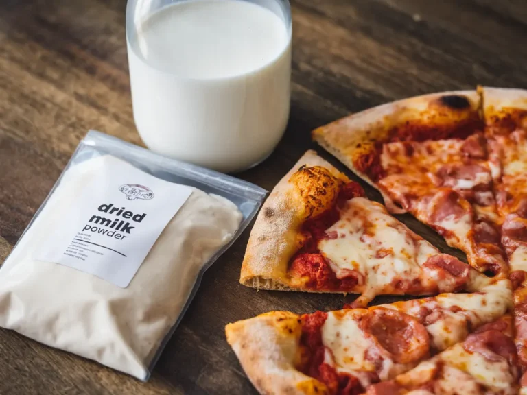 A sliced pizza next to a bottle of milk and a plastic bag with dried milk powder