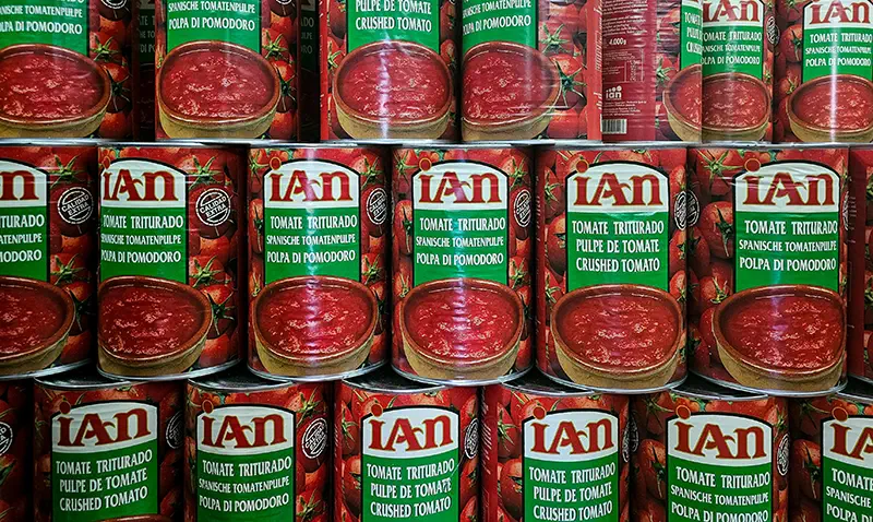 A supermarket shelf with canned crushed tomatoes